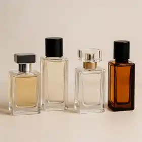 Collection de flacons de parfums élégants alignés sur fond beige, illustrant la diversité des parfums abordables disponibles en Algérie.
